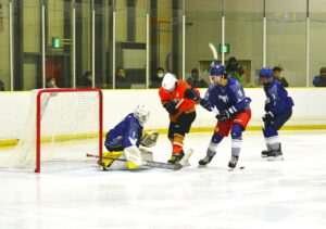 アイスホッケー成年準決勝で東京のゴールを攻める長野（赤）＝４日、岡山国際スケートリンク