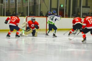 アイスホッケー成年１回戦で和歌山を攻める岡山（白のユニホーム）＝１日、岡山国際スケートリンク