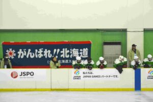 アイスホッケー少年２回戦で応援旗を背に試合を見つめる北海道の選手ら＝３日、ヘルスピア倉敷