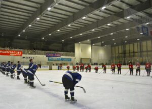 アイスホッケー成年１回戦が終了し挨拶する沖縄県チームと福島県チーム（青）＝１日、岡山国際スケートリンク
