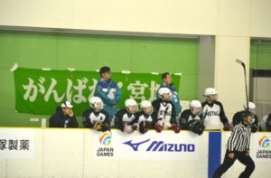 アイスホッケー少年２回戦で応援旗を背に試合を見つめる宮城県の選手ら＝３日、ヘルスピア倉敷
