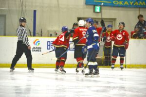 アイスホッケー成年１回戦でゴールを決め喜ぶ沖縄県チーム（赤）＝１日、岡山国際スケートリンク