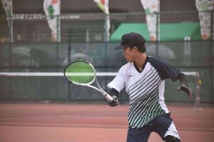 ソフトテニス成年男子準決勝で戦う宮城の佐藤選手＝４日、長浜市民庭球場