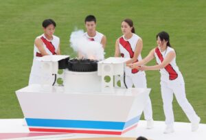 総合開会式で、炬火を点火する陸上の桐生祥秀選手（中央左）と元競泳の大橋悠依さん（同右）ら＝２８日