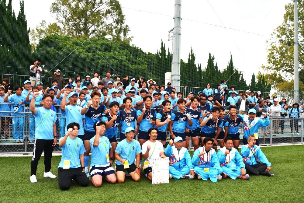 ラグビー成年男子決勝で優勝した佐賀県チームと応援団＝８日、SAGAサンライズパークボールフィールド